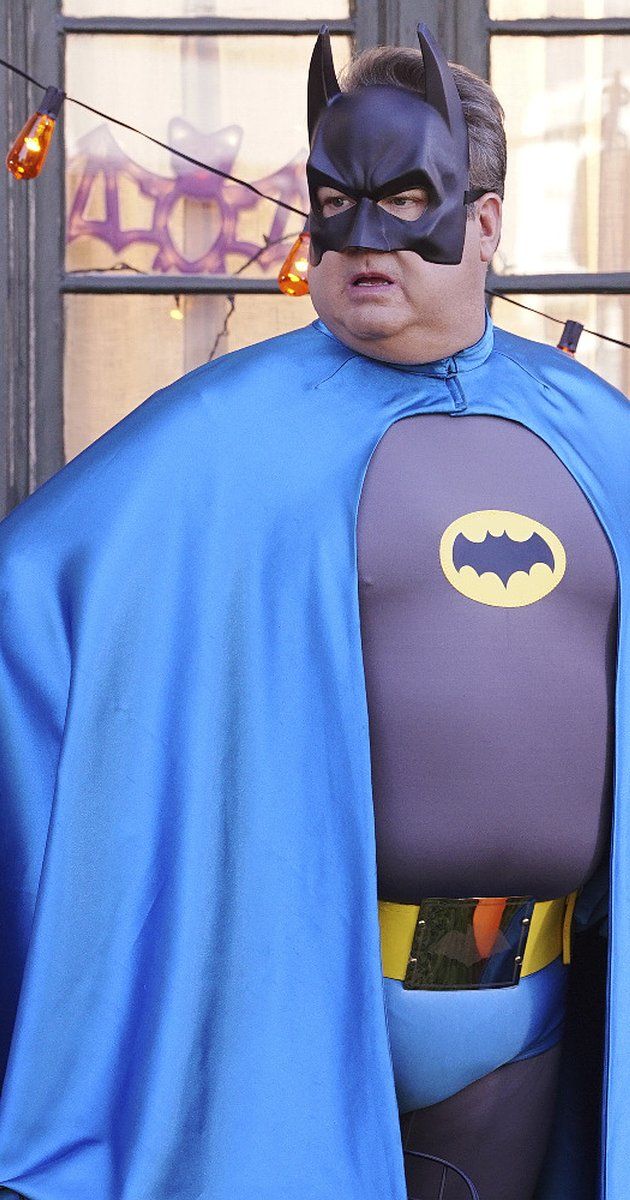 a man dressed as batman standing in front of a building