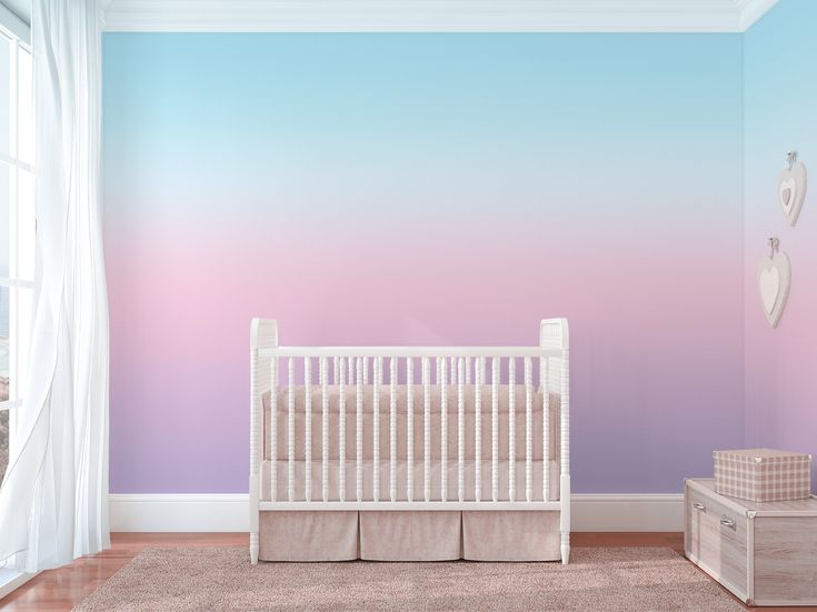 a baby's room with a crib, dresser and wall mural in pastel tones