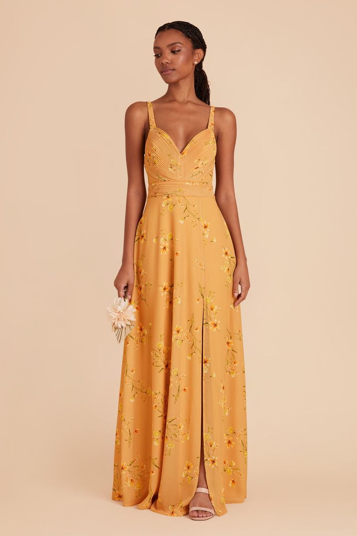 a woman in a yellow dress with flowers on it