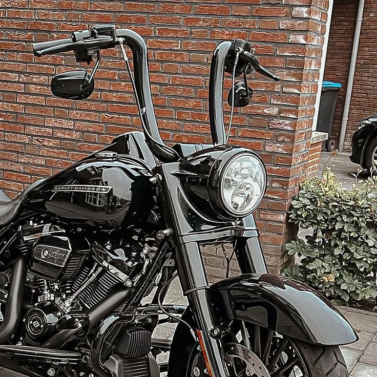 a black motorcycle parked in front of a brick building