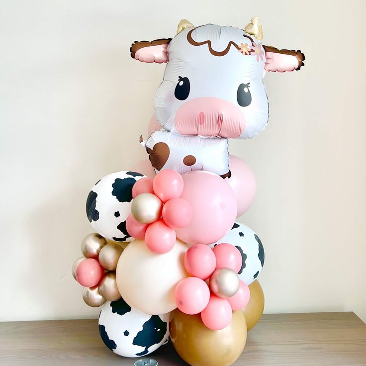 a cow balloon sitting on top of some balloons