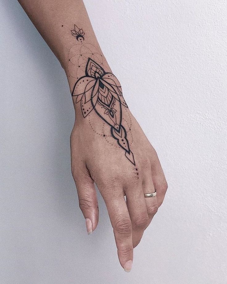 a woman's hand with a small tattoo on the left side of her arm