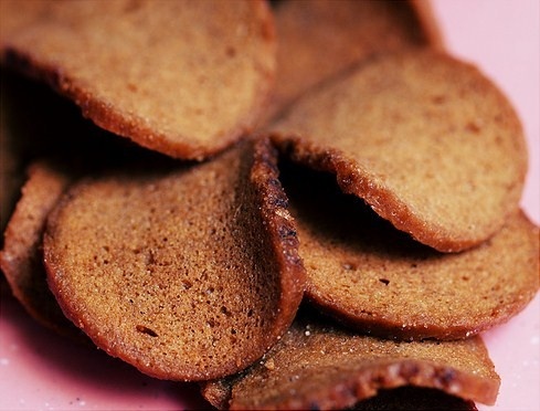 a pile of crackers sitting on top of a pink plate next to each other