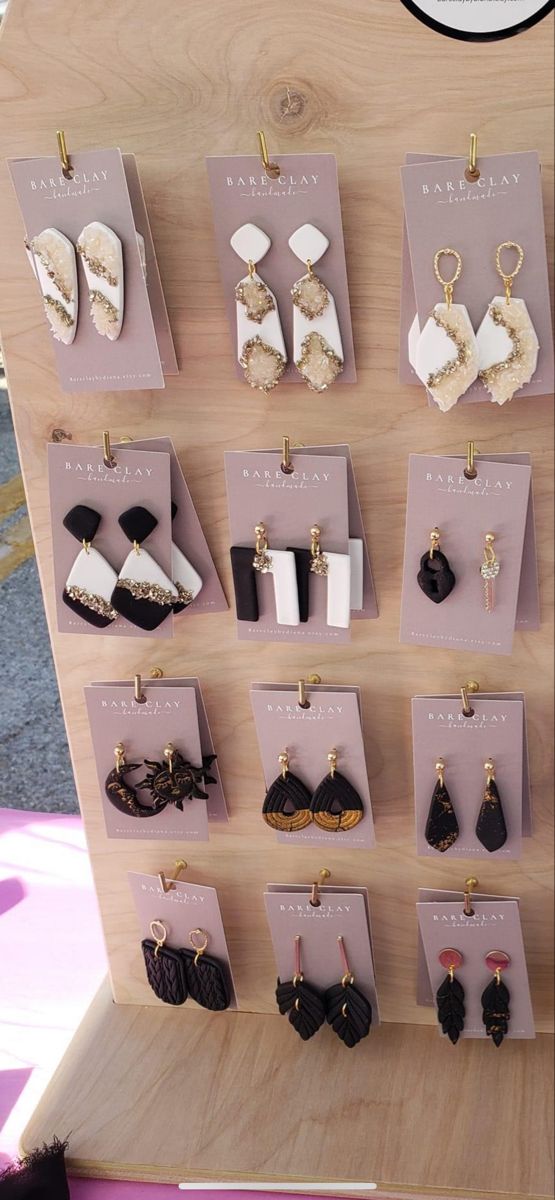 there are many different types of earrings displayed on the display stand with price tags attached to them