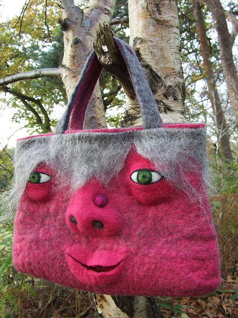 a handbag made to look like a pig's head is hanging from a tree