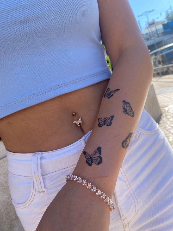 a woman's arm with butterfly tattoos on it and a diamond bracelet attached to the wrist