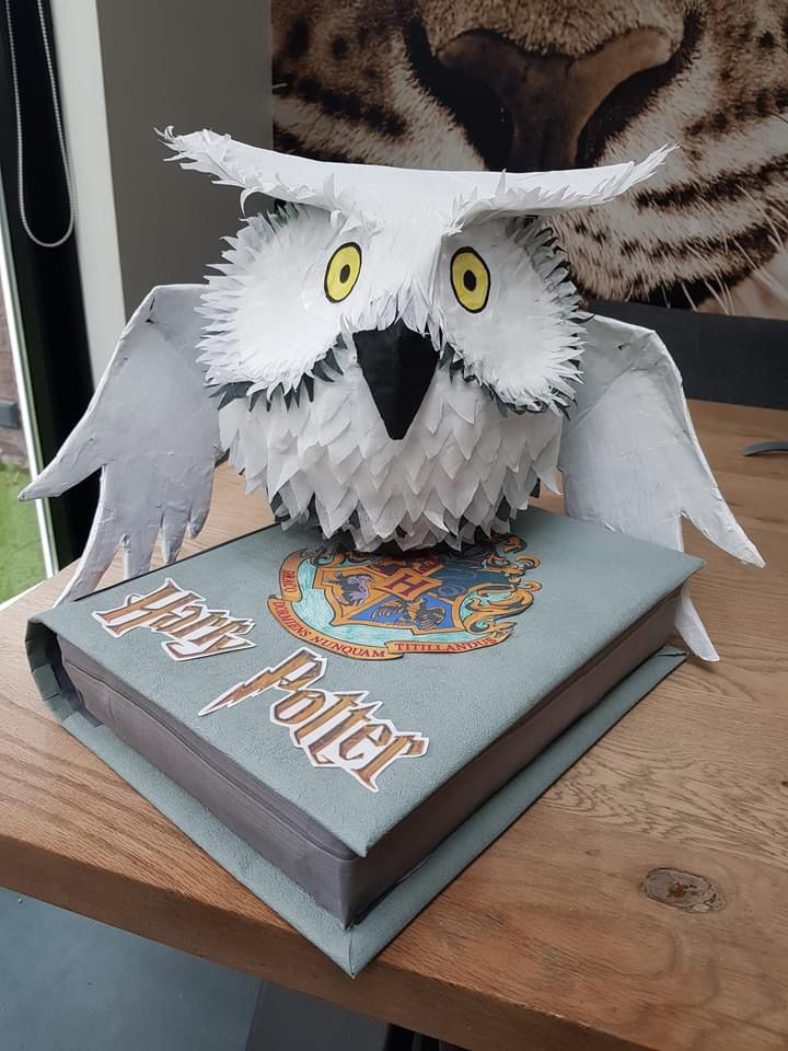 an origami owl sitting on top of a harry potter book with its wings folded