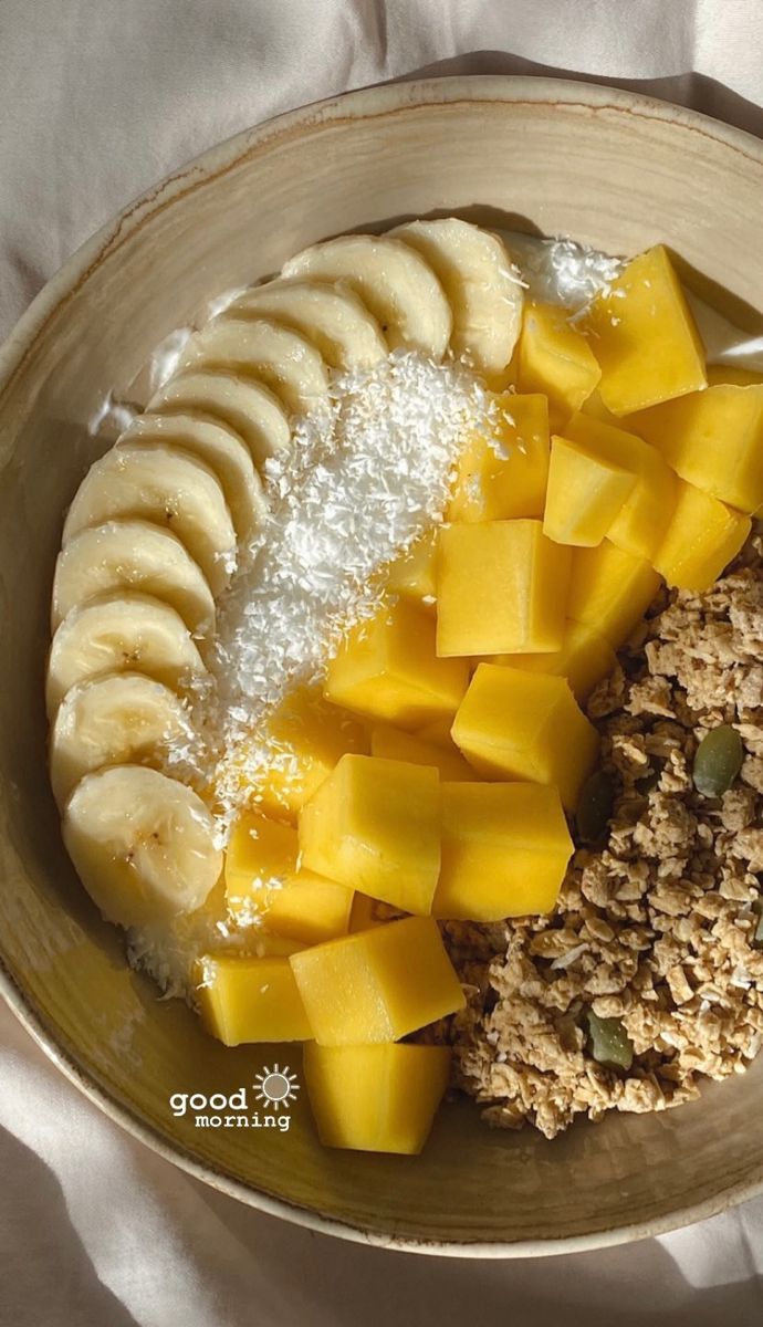 a bowl filled with granola, sliced bananas and other food items on top of it