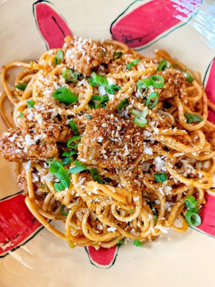 a plate with spaghetti, meat and vegetables on it is shown in the image above