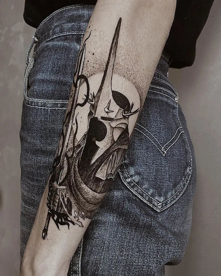 a person with a knife and skull tattoo on their arm