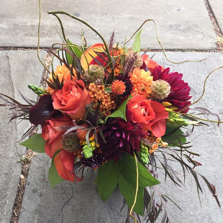 a bouquet of flowers sitting on top of a sidewalk