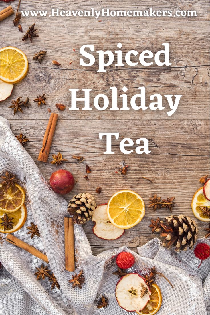 the words spiced holiday tea surrounded by sliced apples, oranges and pine cones