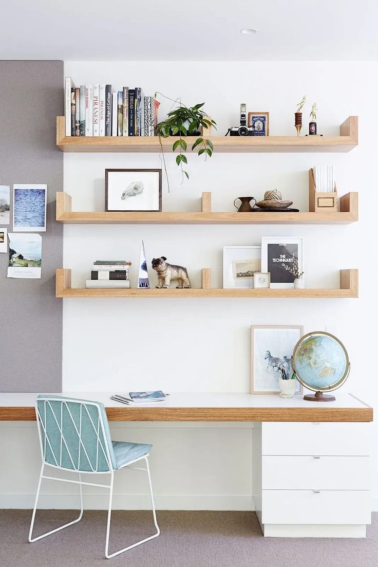 a white desk topped with shelves filled with books and pictures next to a blue chair