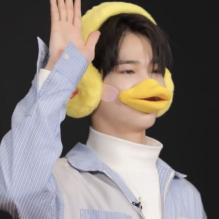 a man wearing a duck mask and holding his hand up