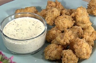 a plate with some fried food and a bowl of ranch dressing on the side next to it