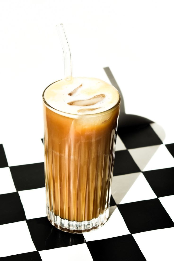 an iced drink sitting on top of a black and white checkered table