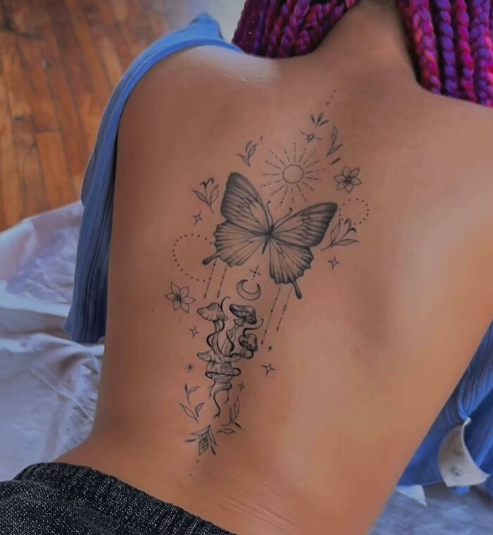 a woman with a butterfly tattoo on her back