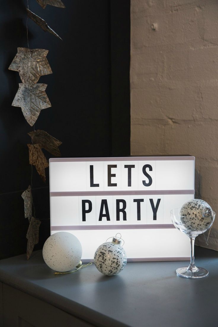 a sign that says let's party on it next to some wine glasses and decorations