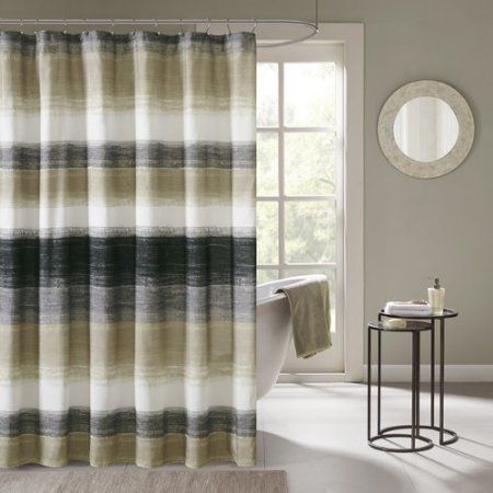 a bath room with a shower curtain and a rug on the floor in front of a window