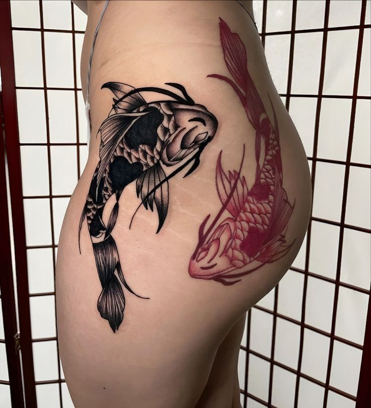 a woman's thigh with a tattoo of a fish and koi carps on it