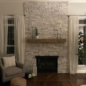 a living room filled with furniture and a fire place in front of a brick wall