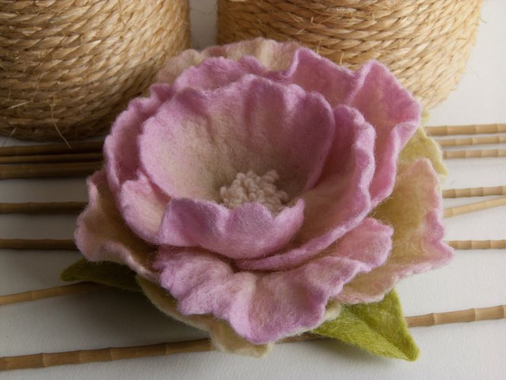 a pink flower sitting on top of some bamboo sticks