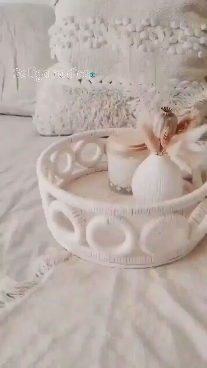 a white tray with two candles on it sitting on top of a bed next to pillows