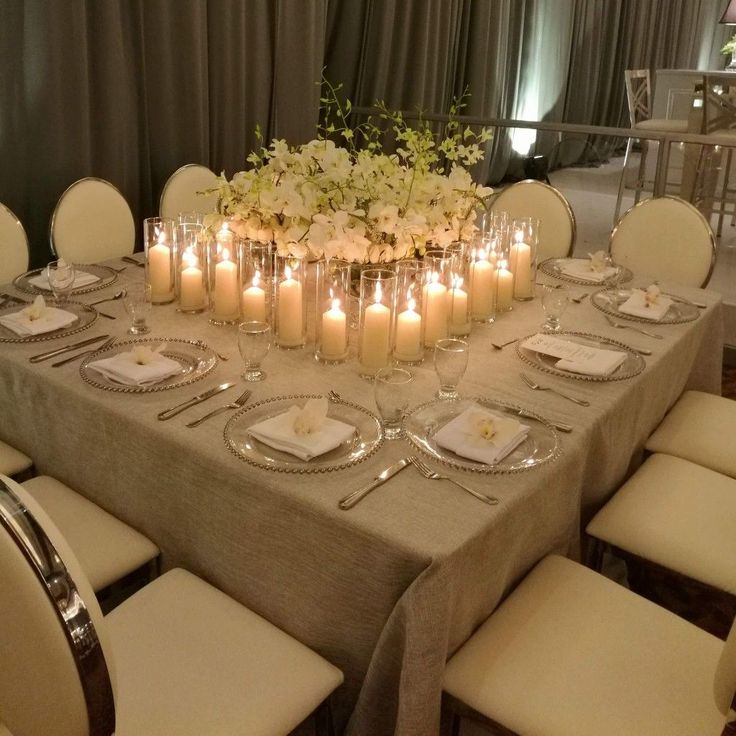 a dining table with candles and place settings