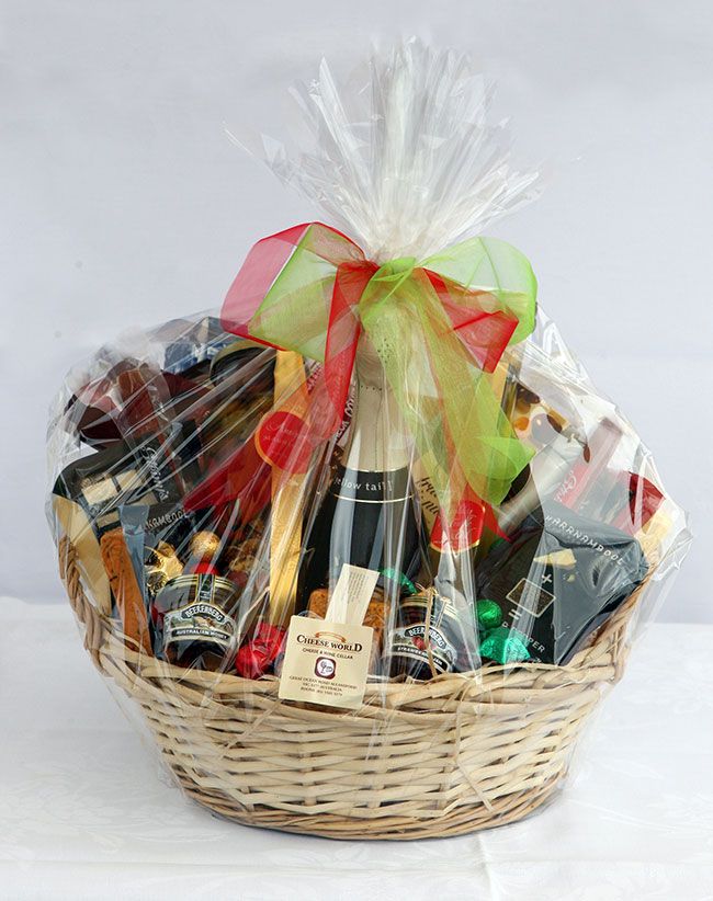 a wicker basket filled with assorted wine and chocolates, wrapped in cellophane