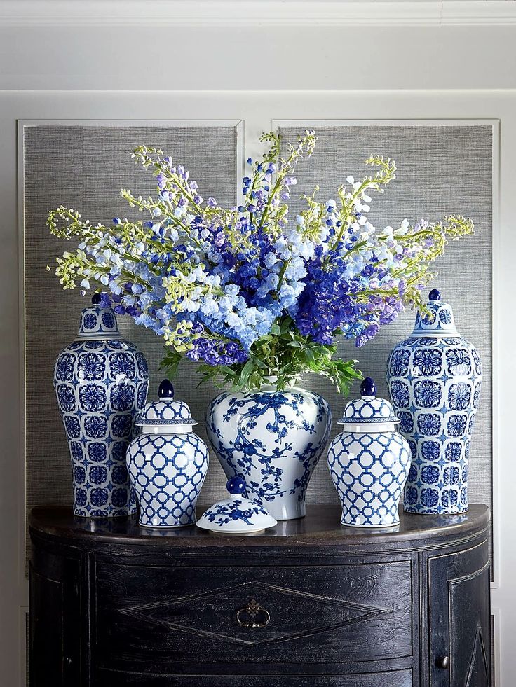 blue and white vases sitting on top of a table