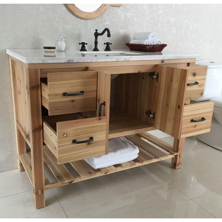 a bathroom vanity with two drawers and a mirror on the wall above it that is made out of wood