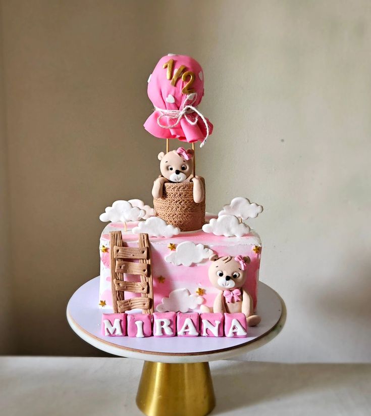 there is a pink cake with teddy bears on it and the name mirana on top