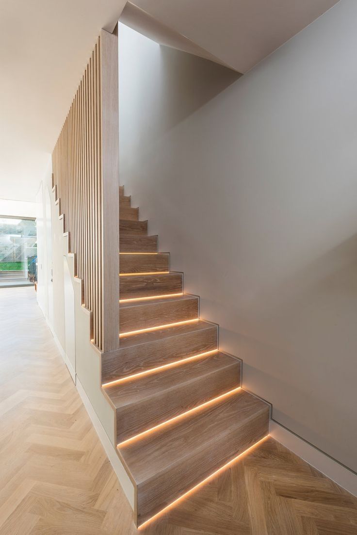 the stairs are illuminated with leds in this modern home interior design, which features herringbone wood flooring and white walls