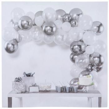 a table topped with lots of silver balloons