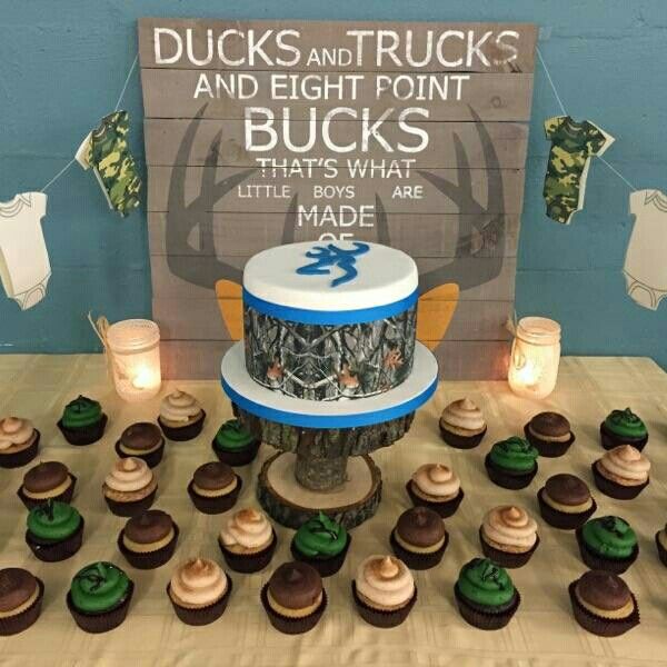 a table topped with lots of cupcakes next to a sign that says ducks and trucks and eight point buck's