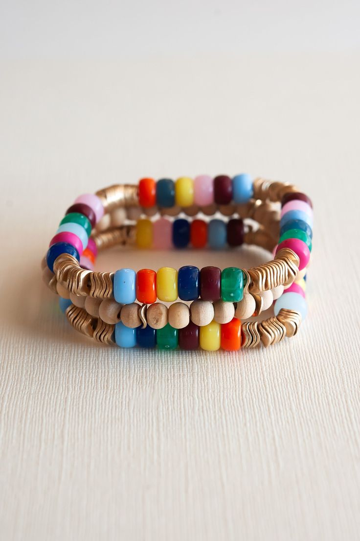 Infuse your style with the vibrant spirit of June through the captivating Rainbow and Wood Beaded Bracelet Set. This delightful stack of bracelets showcases a lively array of colorful beads that exude the radiance of a rainbow, elegantly complemented by intricate gold details. The harmonious blend of wooden elements adds an earthy touch to the ensemble, balancing the vivid hues with a natural charm. This playful yet sophisticated accessory effortlessly brightens any outfit, making it an essentia Adjustable Multicolor Hand Wrapped Bracelets, Multicolor Beaded Wrap Bracelet For Friendship, Multicolor Large Beads Bracelets For Beach, Multicolor Round Beads Wrap Bracelet For Friendship, Bohemian Multicolor Friendship Bracelets With Spacer Beads, Multicolor Bangle Wrap Bracelet For Friendship, Adjustable Multicolor Hand Wrapped Beaded Bracelets, Beach Bracelets With Large Multicolor Beads, Bohemian Multicolor Stretch Bracelet For Beach