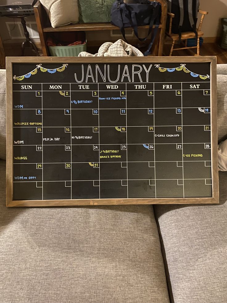 a chalkboard calendar sitting on top of a couch