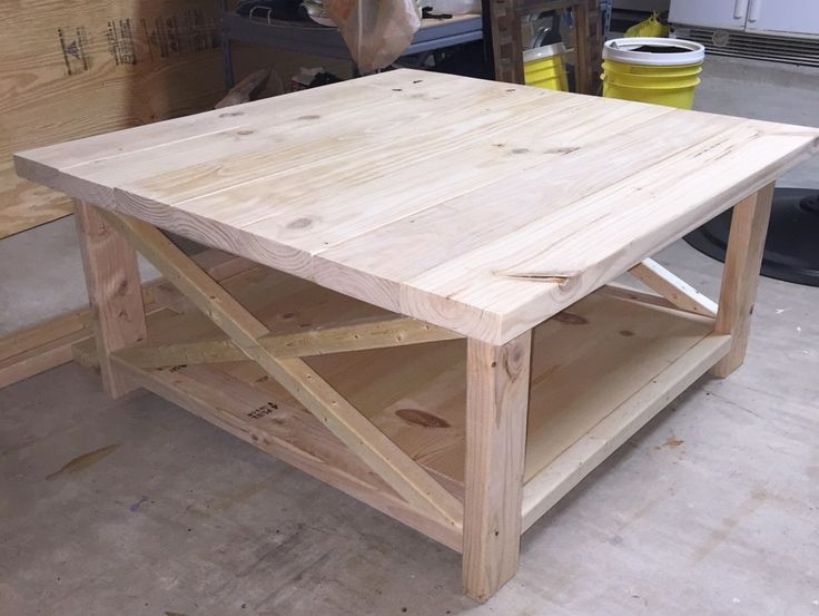 a coffee table made out of plywood in a garage with workbench behind it