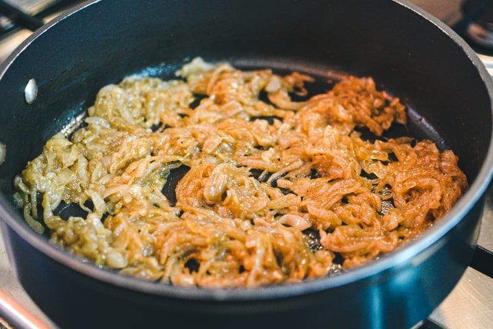 fried food being cooked in a frying pan on top of an electric burner