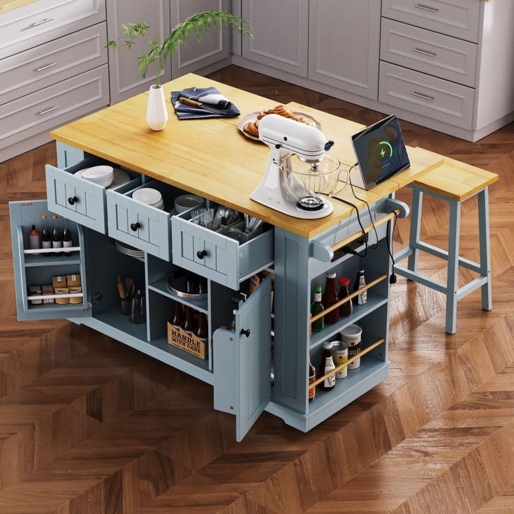 a kitchen island with an open drawer on the top and drawers below it, in front of a wooden floor