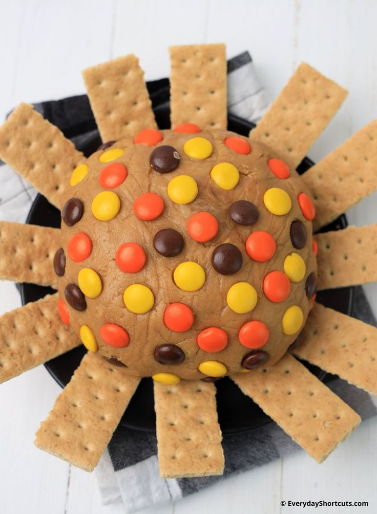 a chocolate covered cookie with candy corn and sprinkles in the shape of a spider