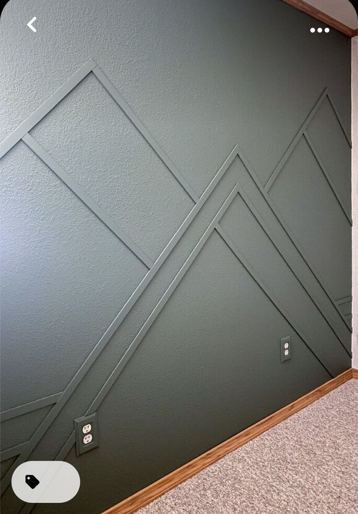 an empty room with a wall painted green and white lines on the wall, in front of a door