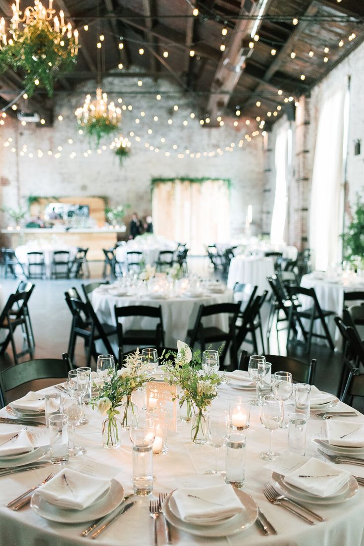 the tables are set with white linens and place settings