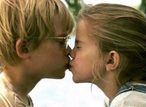 two young women kissing each other in front of a white background with the words love is all around them