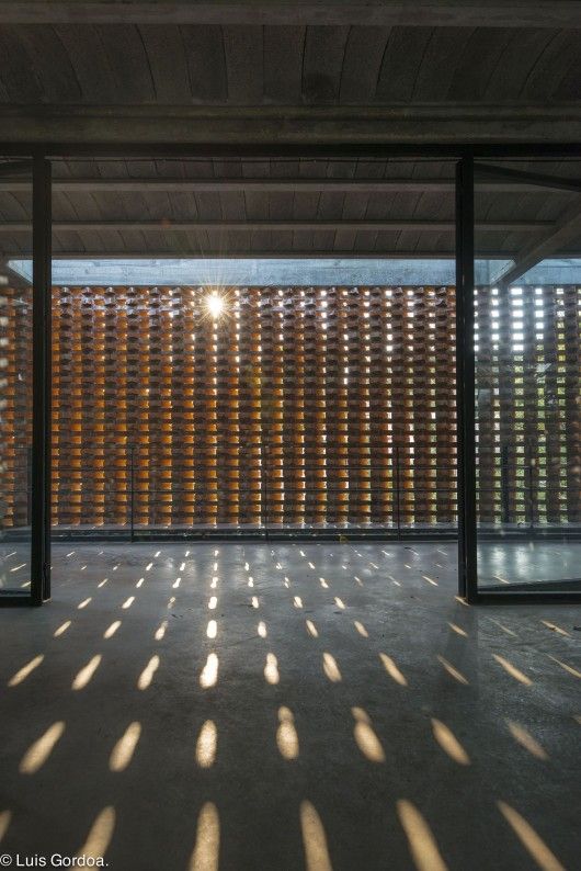 the sun shines through wooden slats in an empty room with concrete flooring