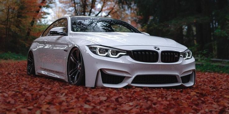 a white car parked on top of a pile of leaves