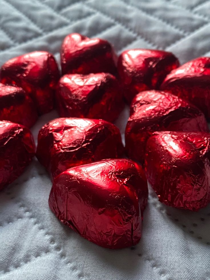 red foiled heart shaped candies on a white tablecloth