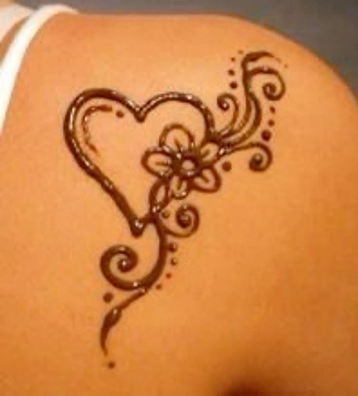 the back of a woman's shoulder with a heart and swirls on it