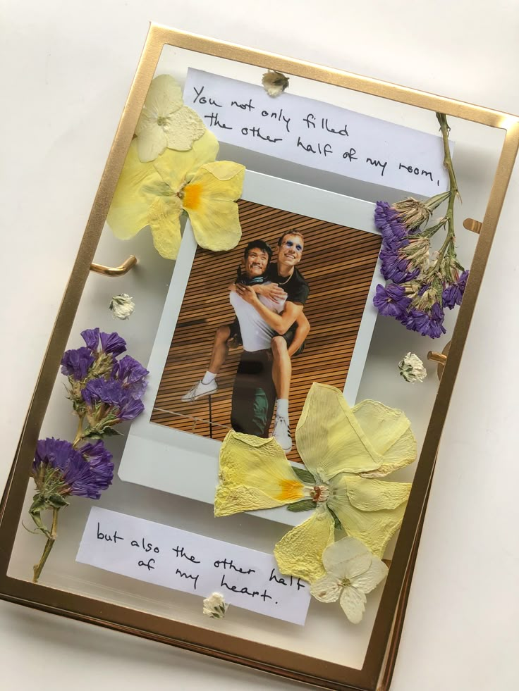 a photo frame with flowers and a couple holding each other