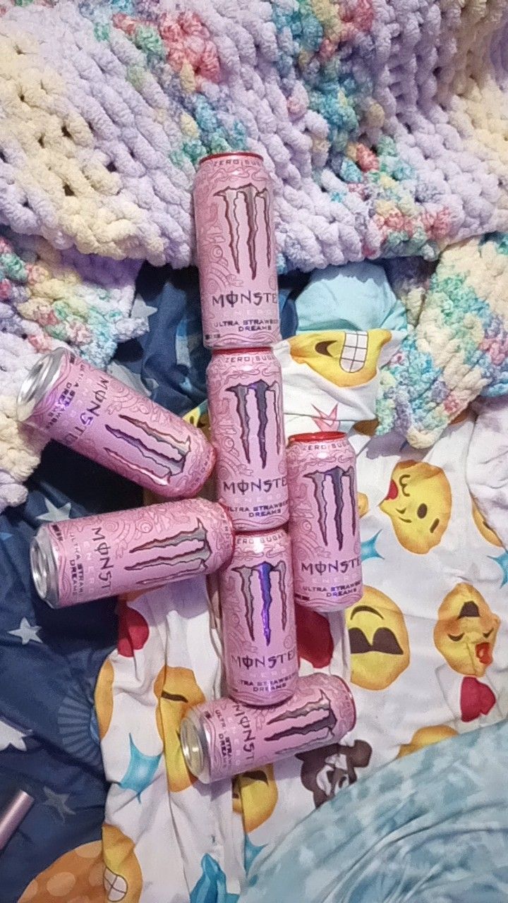 four pink monster lip bales sitting on top of a bed next to a blanket